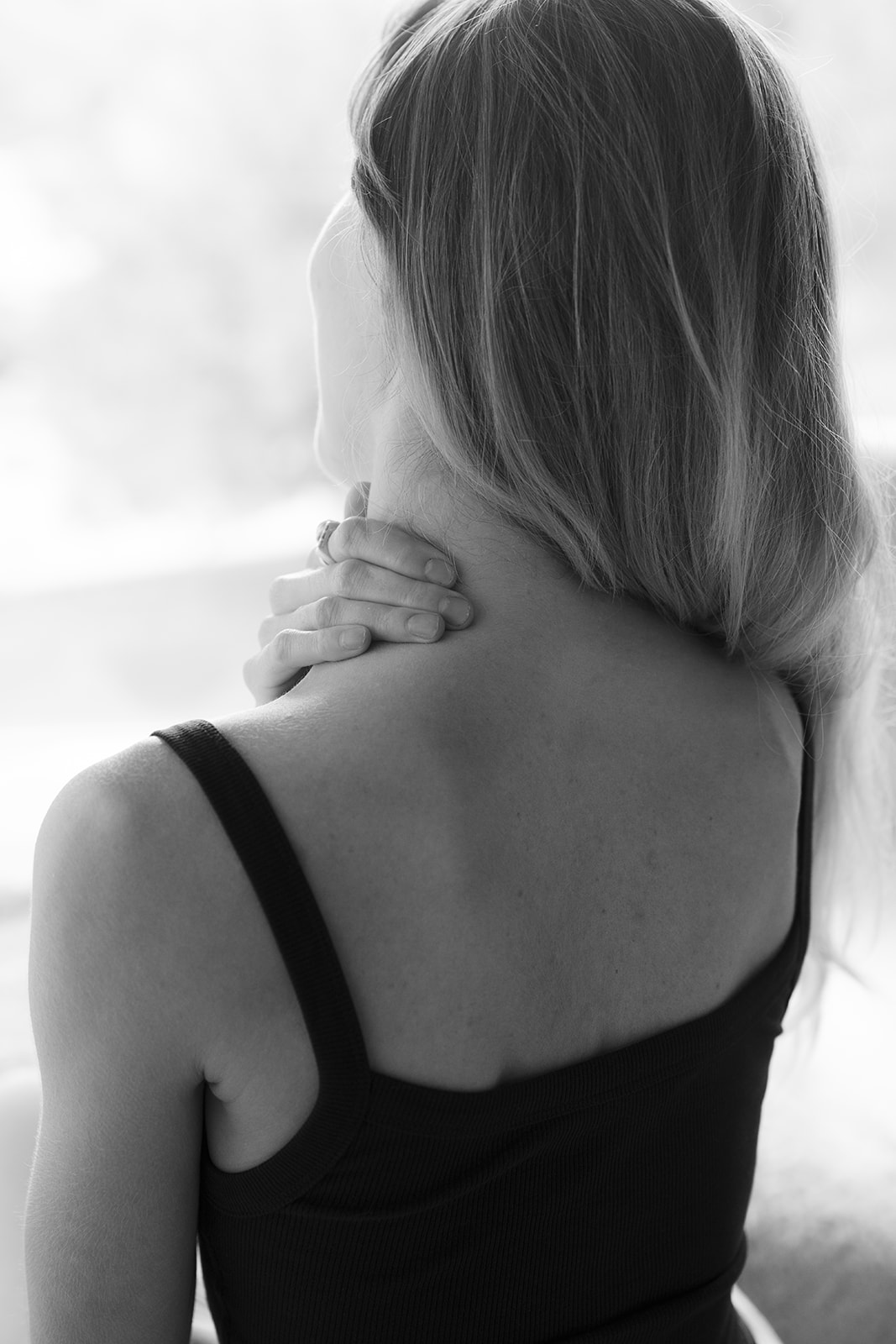 A woman supporting the back of her neck